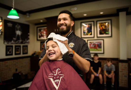 barber drying off a kids hair during a hair cut