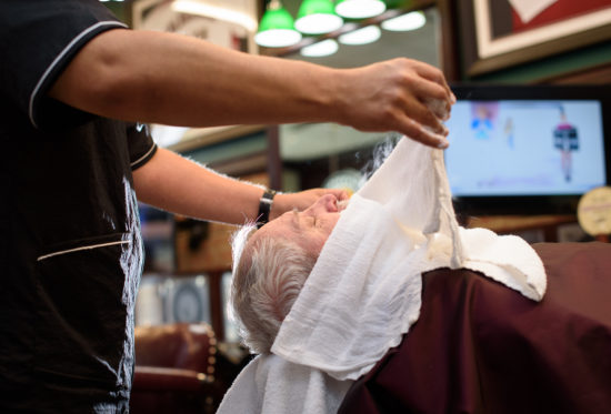 barber applying a hot towel to patron