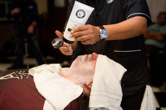 barber applying V's Shave Cream to a patron during a shave