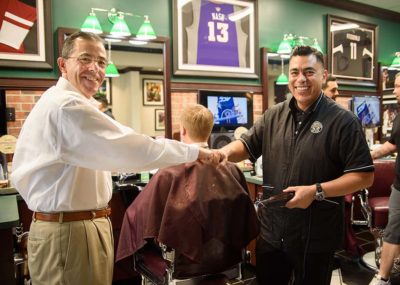 barber and owner of V's Barbershop, Jim Valenzuela, shaking hands